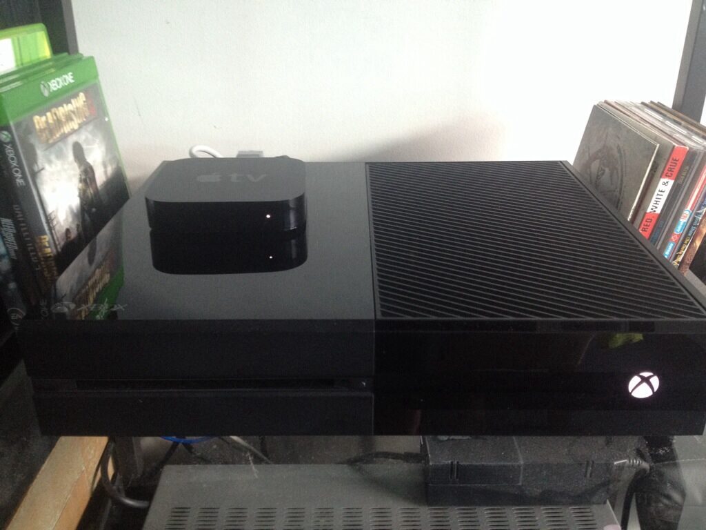 An Xbox One with an Apple TV 3 on top